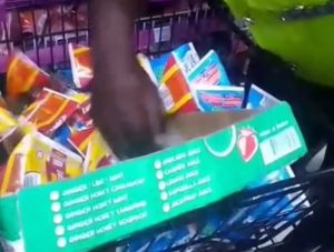 A Lagos official seizing drinks with plastic straws at a retail store